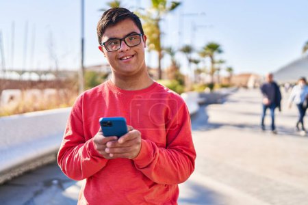 Photo for Down syndrome man smiling confident using smartphone at street - Royalty Free Image
