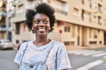 Téléchargez les photos : Jeune femme africaine souriante confiante dans la rue - en image libre de droit