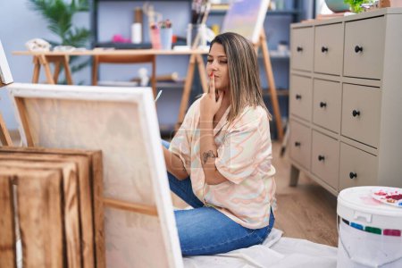 Téléchargez les photos : Young hispanic woman artist looking draw with doubt expression at art studio - en image libre de droit