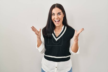 Photo for Young hispanic woman standing over isolated background celebrating crazy and amazed for success with arms raised and open eyes screaming excited. winner concept - Royalty Free Image