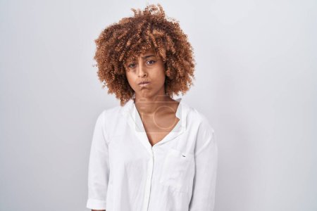 Photo for Young hispanic woman with curly hair standing over white background skeptic and nervous, frowning upset because of problem. negative person. - Royalty Free Image