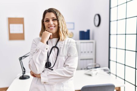 Photo for Young hispanic woman wearing doctor stethoscope with arms crossed gesture at clinic - Royalty Free Image