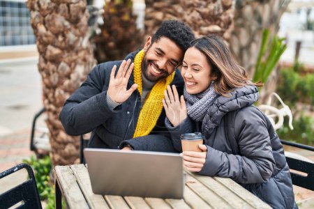 Téléchargez les photos : Homme et femme couple ayant appel vidéo boire du café à la terrasse du café - en image libre de droit