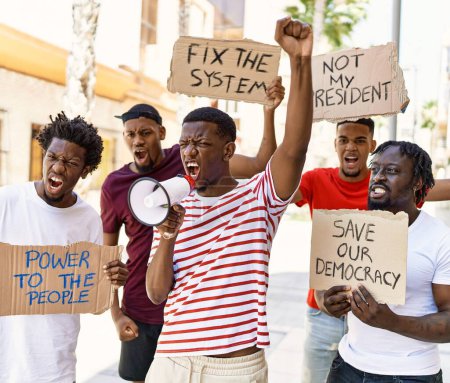 Téléchargez les photos : Group of young african american activists protesting holding banner and using megaphone at the city. - en image libre de droit