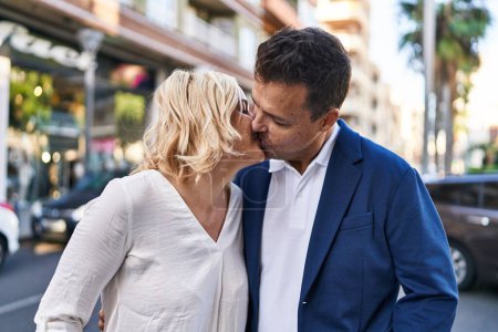Photo for Middle age man and woman couple hugging each other and kissing standing at street - Royalty Free Image