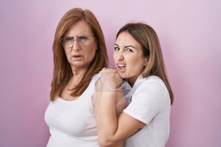 Foto de Madre e hija hispanas usando una camiseta blanca casual sin idea y expresión confusa. concepto de duda. - Imagen libre de derechos
