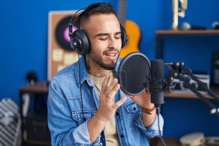Téléchargez les photos : Young hispanic man artist singing song at music studio - en image libre de droit