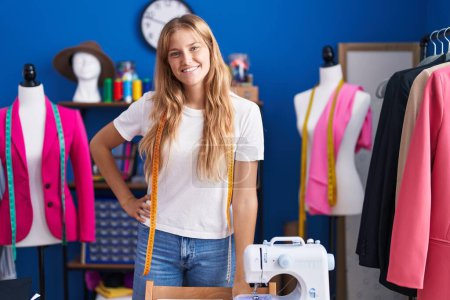 Photo for Young blonde girl tailor smiling confident standing at sewing studio - Royalty Free Image