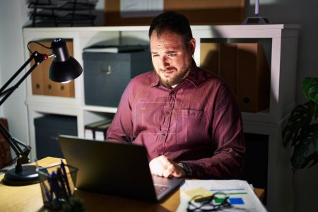 Téléchargez les photos : Plus size hispanic man with beard working at the office at night depressed and worry for distress, crying angry and afraid. sad expression. - en image libre de droit