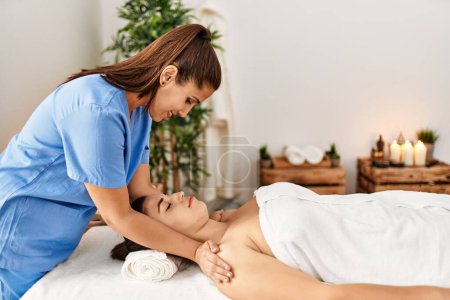 Téléchargez les photos : Deux femmes thérapeute et patiente ayant une séance de massage facial au centre de beauté - en image libre de droit