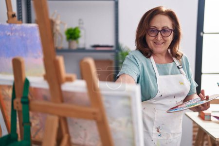 Foto de Senior woman artist smiling confident drawing at art studio - Imagen libre de derechos