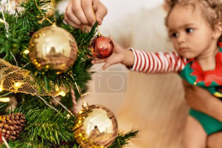 Téléchargez les photos : Couple et fille souriant confiant décoration arbre de Noël à la maison - en image libre de droit
