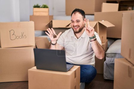 Téléchargez les photos : Plus size hispanic man with beard moving to a new home doing video call smiling with an idea or question pointing finger with happy face, number one - en image libre de droit
