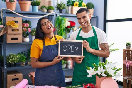 Photo for Young hispanic couple working at florist with open sign smiling and laughing hard out loud because funny crazy joke. - Royalty Free Image