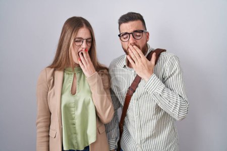 Photo for Young couple standing over white background bored yawning tired covering mouth with hand. restless and sleepiness. - Royalty Free Image