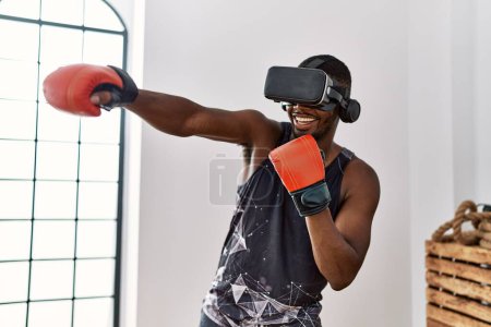 Photo for Young african american man boxing using vr glasses at sport center - Royalty Free Image