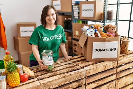 Brunette woman with down syndrome by box checking donated toys and charity jar at donations stand
