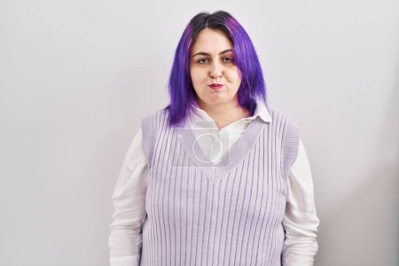 Téléchargez les photos : Plus size woman wit purple hair standing over white background puffing cheeks with funny face. mouth inflated with air, crazy expression. - en image libre de droit