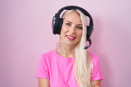Photo for Caucasian woman listening to music using headphones happy face smiling with crossed arms looking at the camera. positive person. - Royalty Free Image