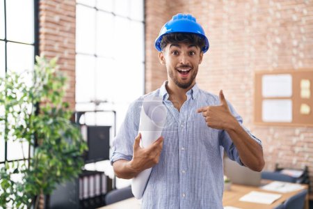 Foto de Arab man with beard wearing architect hardhat at construction office pointing finger to one self smiling happy and proud - Imagen libre de derechos