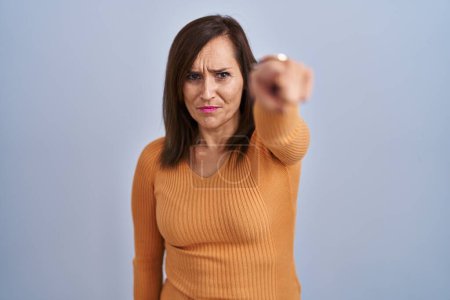 Photo for Middle age brunette woman standing wearing orange sweater pointing displeased and frustrated to the camera, angry and furious with you - Royalty Free Image