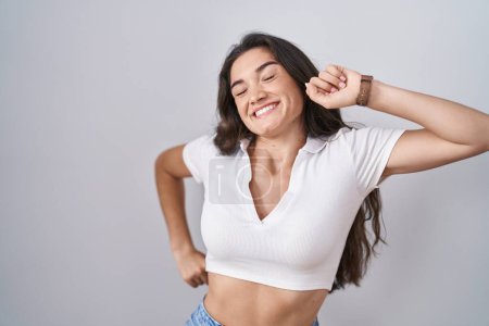 Téléchargez les photos : Young teenager girl standing over white background stretching back, tired and relaxed, sleepy and yawning for early morning - en image libre de droit