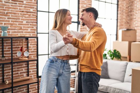 Téléchargez les photos : Young man and woman couple smiling confident dancing at new home - en image libre de droit