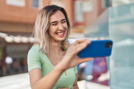 Photo for Young woman smiling confident watching video on smartphone at street - Royalty Free Image
