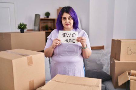 Photo for Plus size woman wit purple hair moving to a new home holding banner relaxed with serious expression on face. simple and natural looking at the camera. - Royalty Free Image