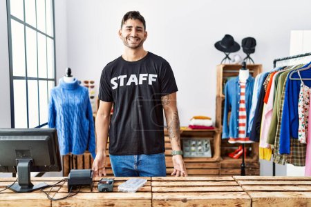 Foto de Joven hombre hispano que trabaja en una boutique con una sonrisa alegre y fresca en la cara. persona afortunada. - Imagen libre de derechos