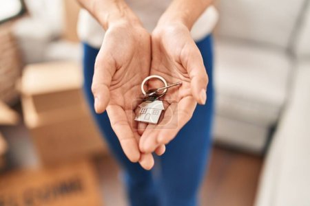 Foto de Joven mujer rubia sosteniendo la llave de la casa en un nuevo hogar - Imagen libre de derechos