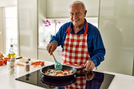 Photo for Senior man smiling confident cooking at kitchen - Royalty Free Image