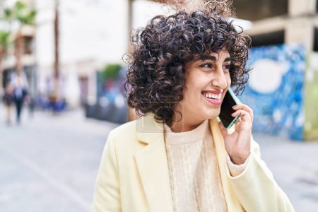 Foto de Young middle east woman excutive smiling confident talking on the smartphone at street - Imagen libre de derechos