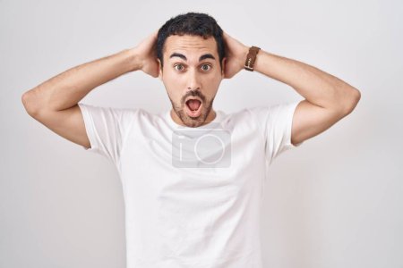 Photo for Handsome hispanic man standing over white background crazy and scared with hands on head, afraid and surprised of shock with open mouth - Royalty Free Image
