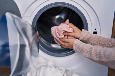 Foto de Mujer joven lavando ropa en la lavandería - Imagen libre de derechos