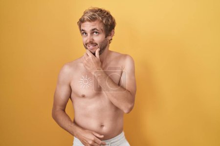 Photo for Caucasian man standing shirtless wearing sun screen thinking worried about a question, concerned and nervous with hand on chin - Royalty Free Image
