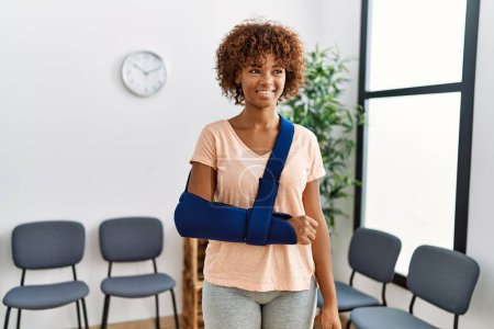Téléchargez les photos : Young african american woman smiling confident injury at clinic waiting room - en image libre de droit