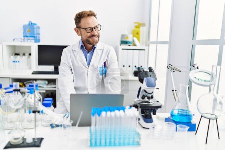 Photo for Middle age hispanic man wearing scientist uniform working at laboratory - Royalty Free Image