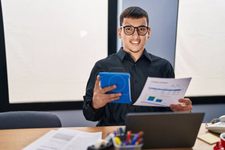 Foto de Joven trabajador de negocios utilizando el documento de lectura touchpad en la oficina - Imagen libre de derechos