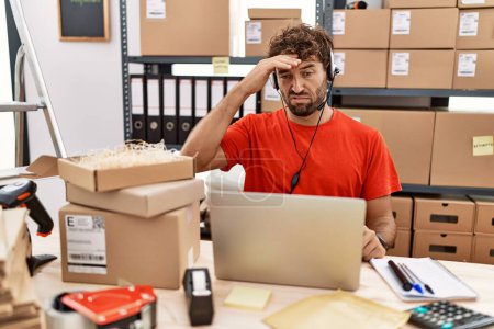 Photo for Young hispanic call center agent man working at warehouse worried and stressed about a problem with hand on forehead, nervous and anxious for crisis - Royalty Free Image