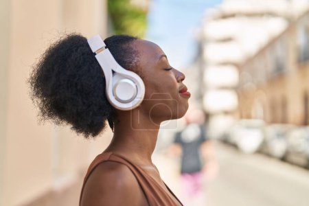 Foto de African american woman relaxed listening to music at street - Imagen libre de derechos