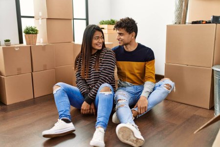 Téléchargez les photos : Young latin couple smiling happy sitting on the floor at new home. - en image libre de droit