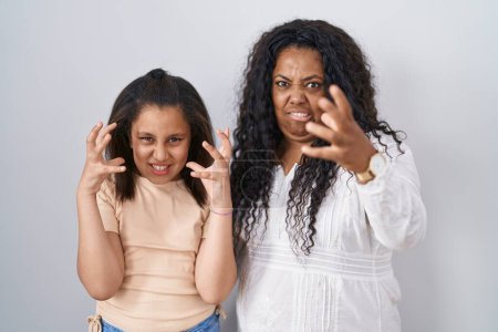 Téléchargez les photos : Mère et jeune fille debout sur fond blanc criant frustrés par la rage, les mains essayant d'étrangler, hurlant fou - en image libre de droit