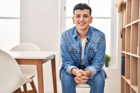 Photo for Young non binary man smiling confident sitting on chair at home - Royalty Free Image