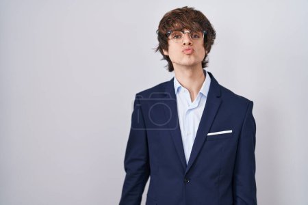 Photo for Hispanic business young man wearing glasses looking at the camera blowing a kiss on air being lovely and sexy. love expression. - Royalty Free Image