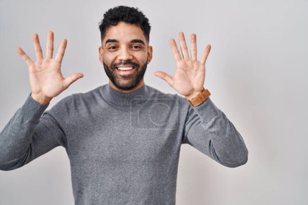 Photo for Hispanic man with beard standing over white background showing and pointing up with fingers number ten while smiling confident and happy. - Royalty Free Image