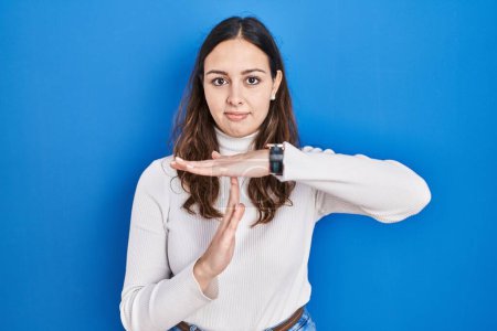 Téléchargez les photos : Jeune femme hispanique debout sur fond bleu faisant un geste avec les mains, frustré et sérieux visage - en image libre de droit