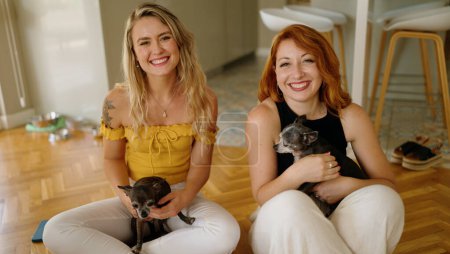 Photo for Two women smiling confident sitting on floor with chihuahuas at home - Royalty Free Image