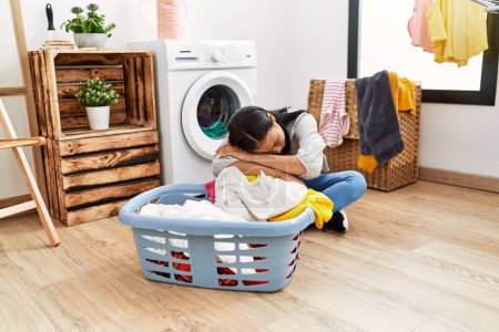 Téléchargez les photos : Jeune femme latine ennuyée attendant la machine à laver à la buanderie - en image libre de droit