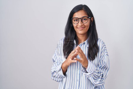 Foto de Mujer hispana joven usando gafas manos juntas y dedos cruzados sonriendo relajada y alegre. éxito y optimismo - Imagen libre de derechos